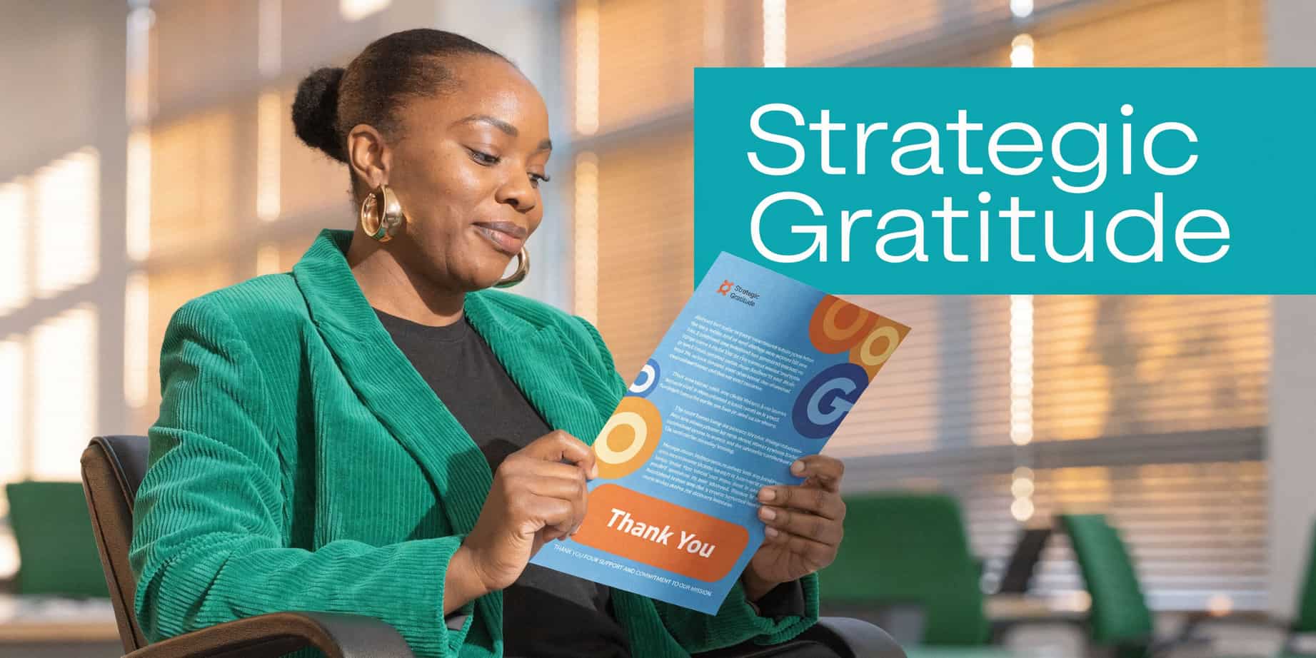 Woman in a green corduroy blazer holding a branded thank you letter in an office