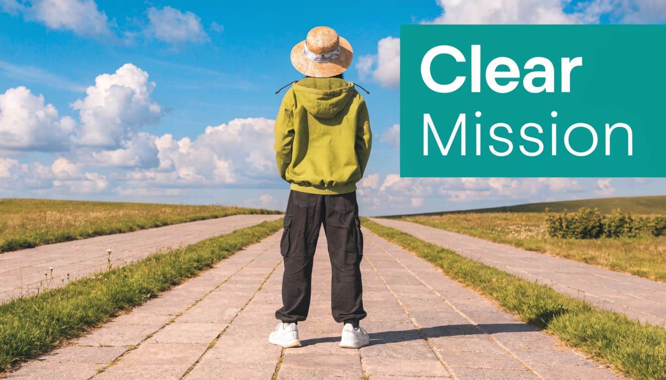 Person wearing a straw hat and green hoodie stands on a path facing a horizon.