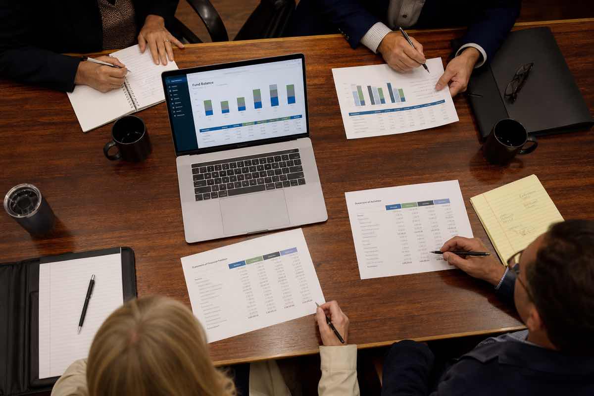 Nonprofit board members reviewing fund-level financial reports at a meeting table