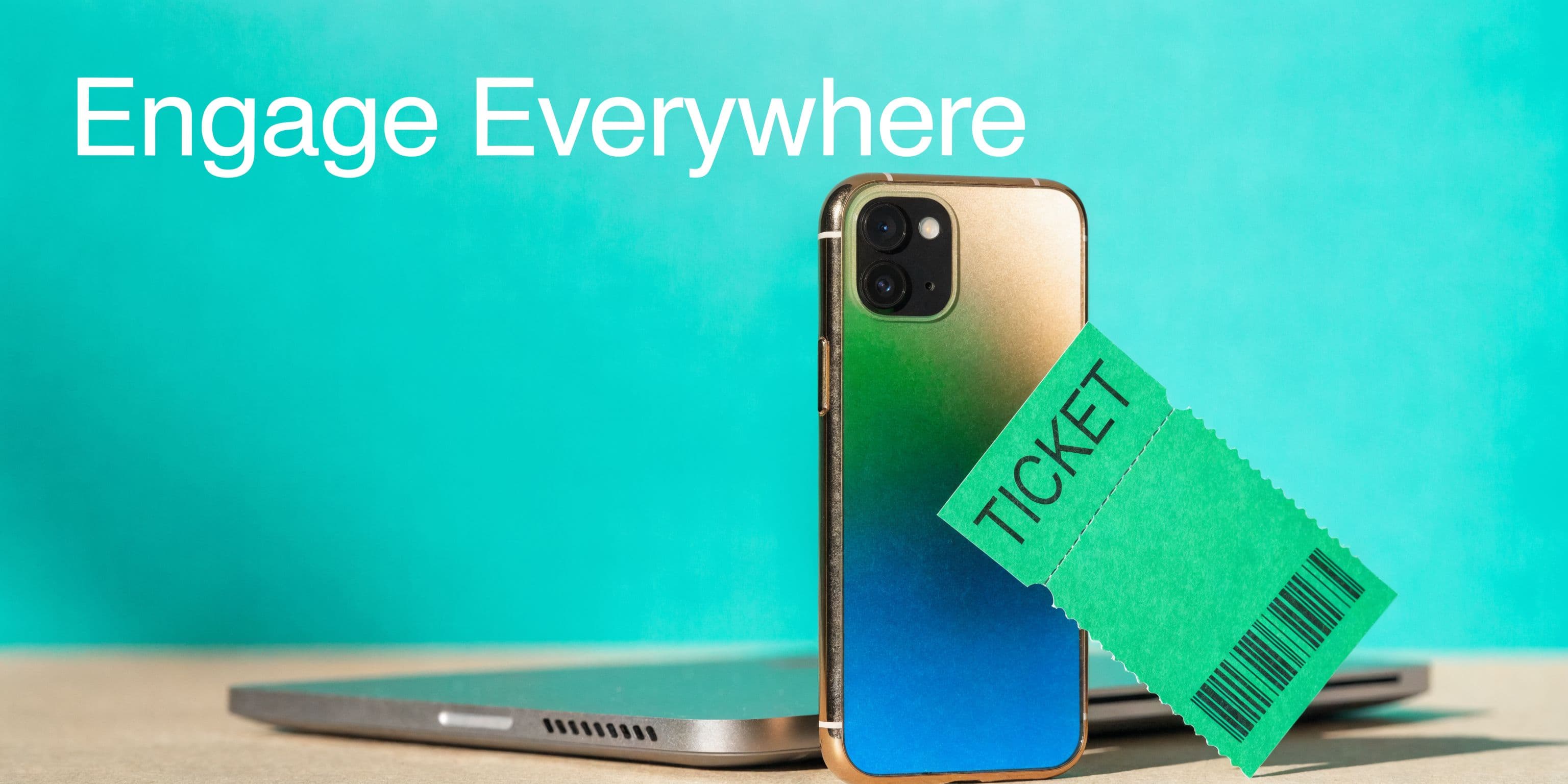 A smartphone with a gradient back rests on a laptop next to a green ticket icon.