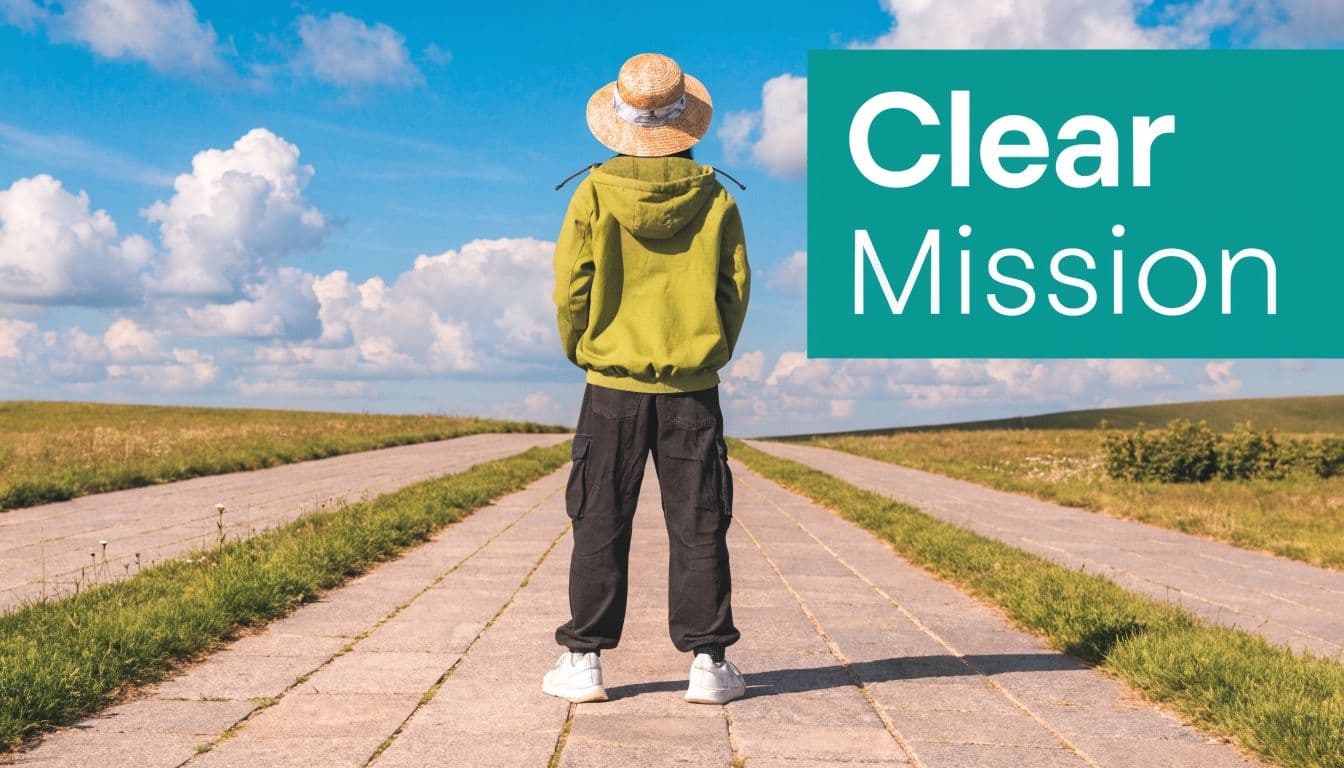 A person wearing a straw hat and green hoodie stands on a path facing a horizon.