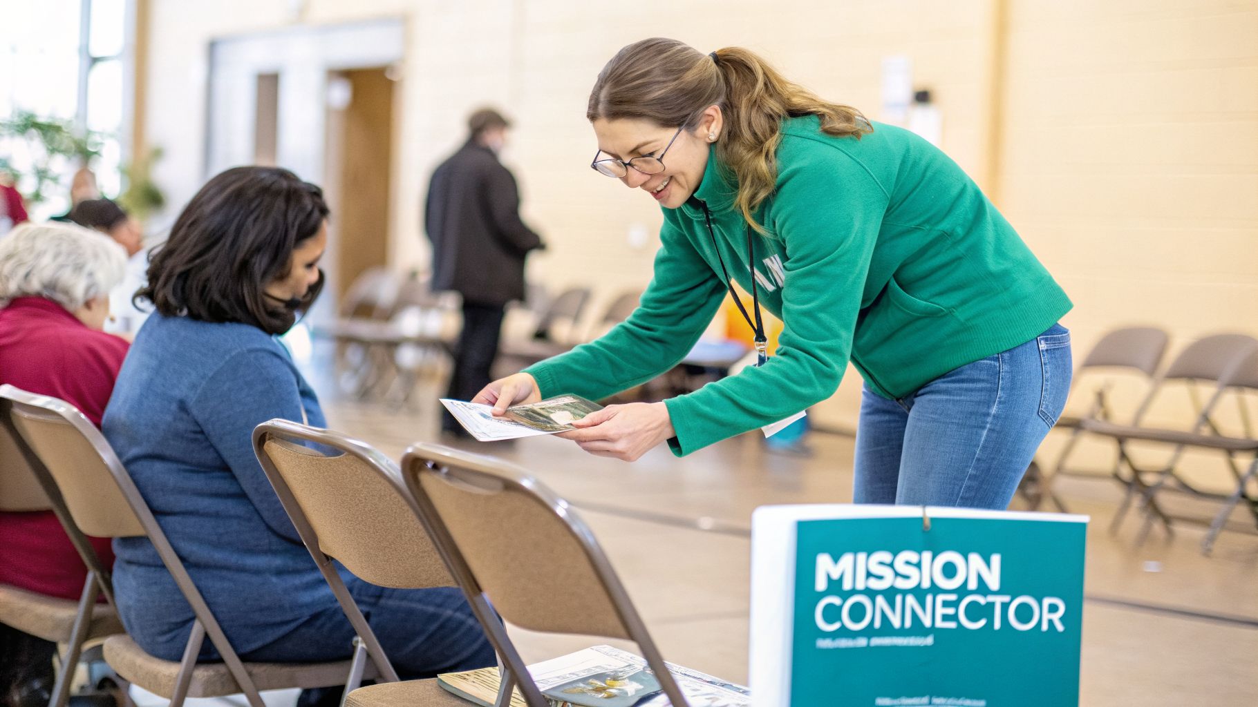 A smiling event coordinator hands brochures to attendees at a community event.